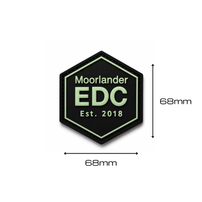 Moorlander EDC glow in the dark PVC morale patch in hexagon design with soft green GITD text on black base shown with 68 millimeter dimensions on a clean white background